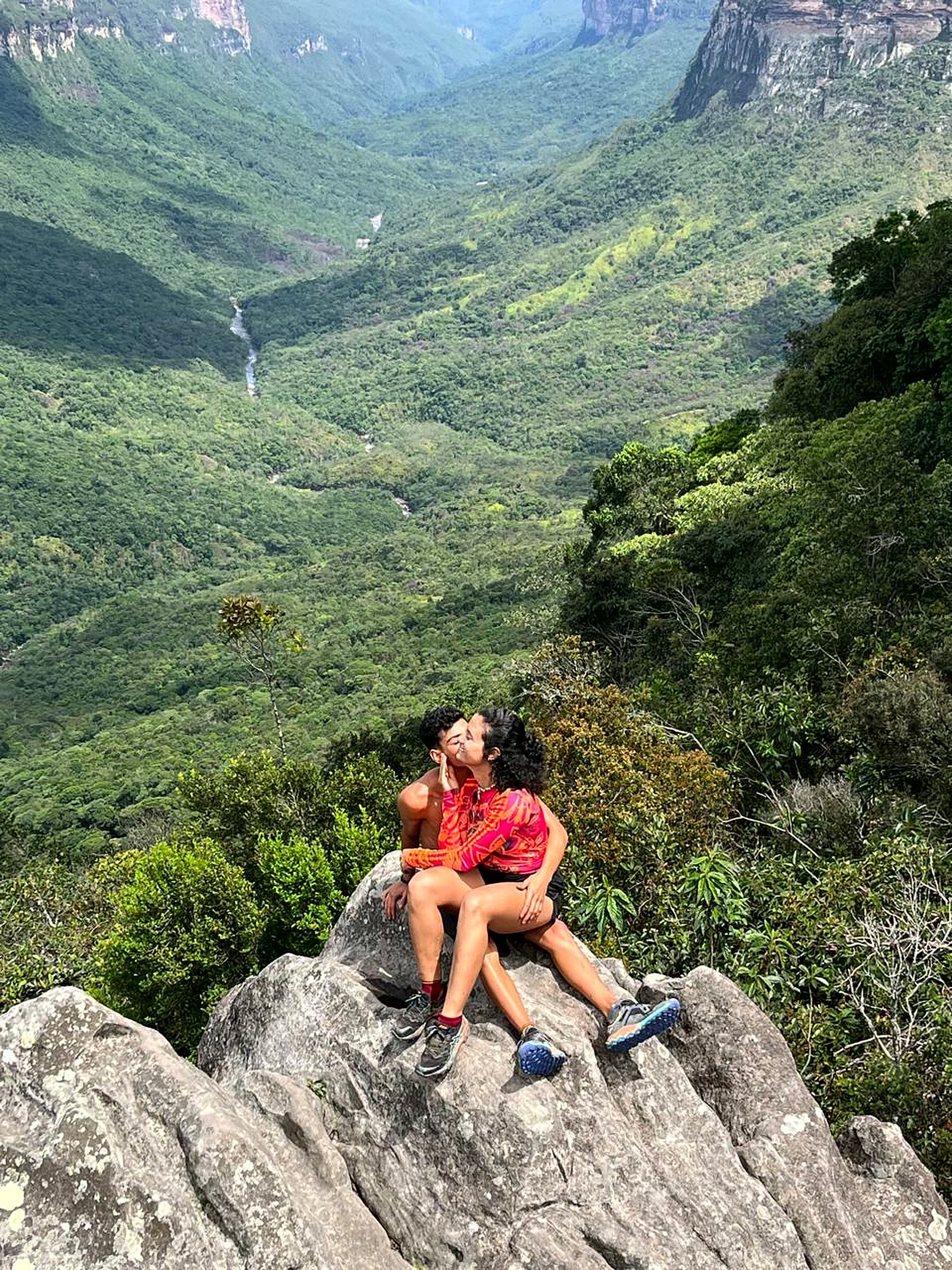 Yonara e Pablo na pedra do mirante com o vale verde ao fundo